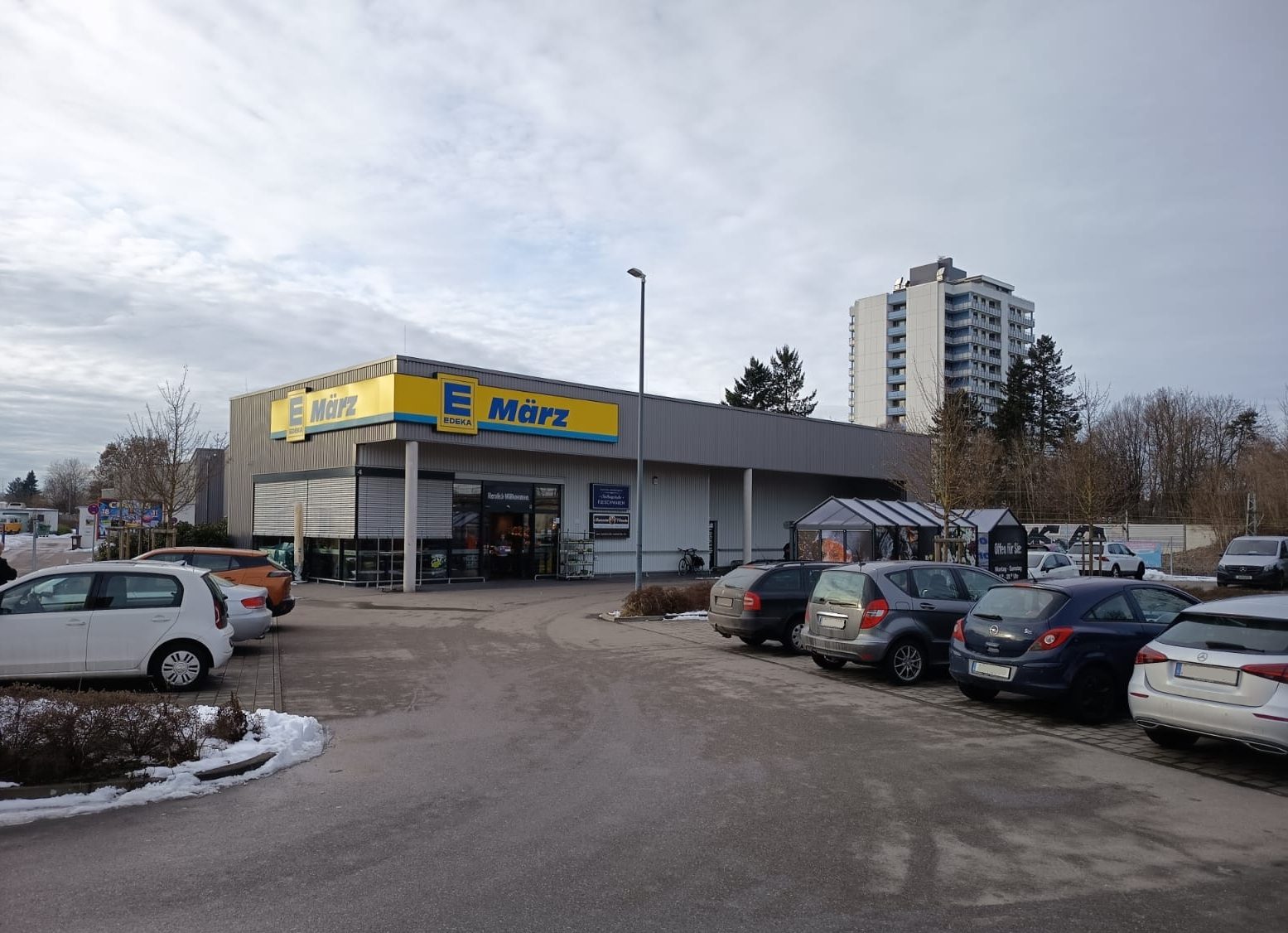 Außenansicht des neu errichteten Marktes Edeka Augsburg mit Parkplatzfläche.