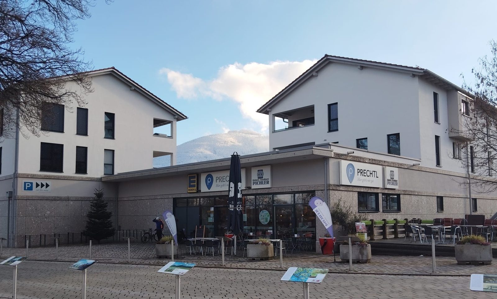 Außenansicht des neu gebauten Edeka Bad Feilnbach in Bad Feilnbach mit Vorplatz und Bäckereibereich.