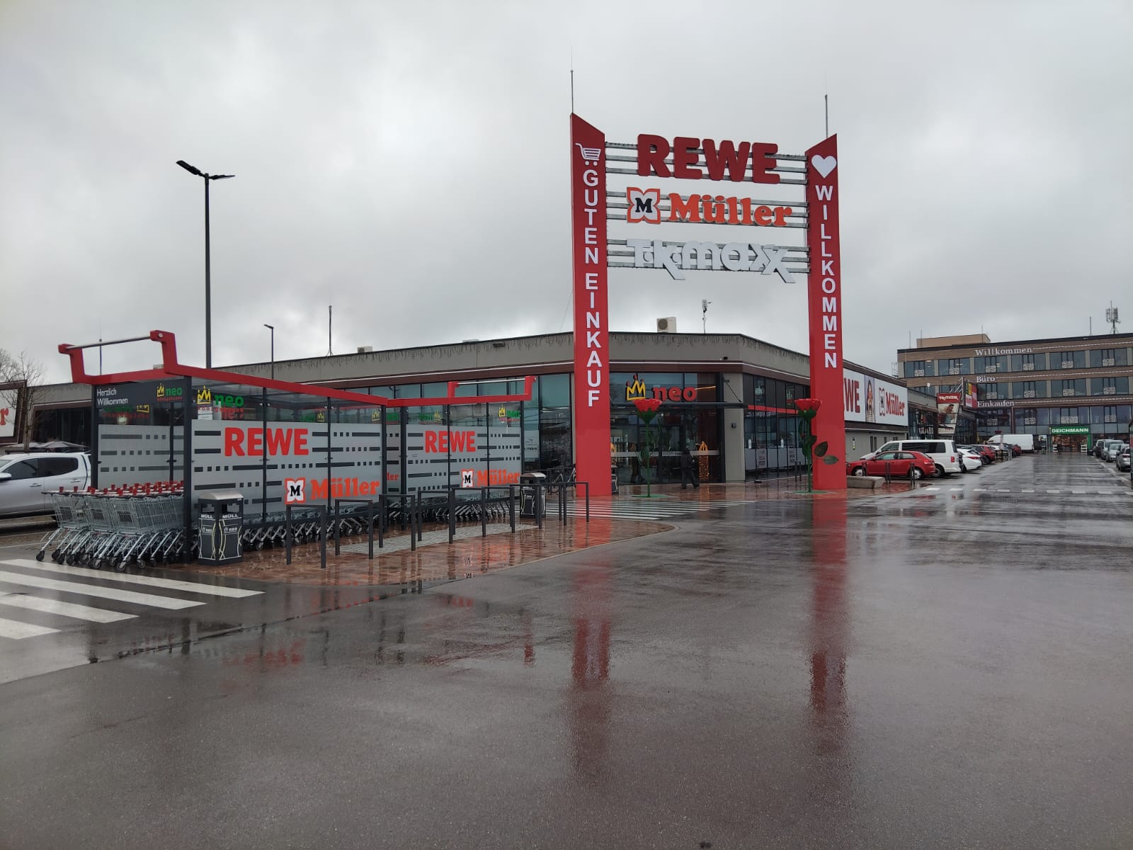 Außenansicht des Neubaus Fachmarktzentrum Königsbrunn in Königsbrunn mit Eingangsbereich und Parkplatz.