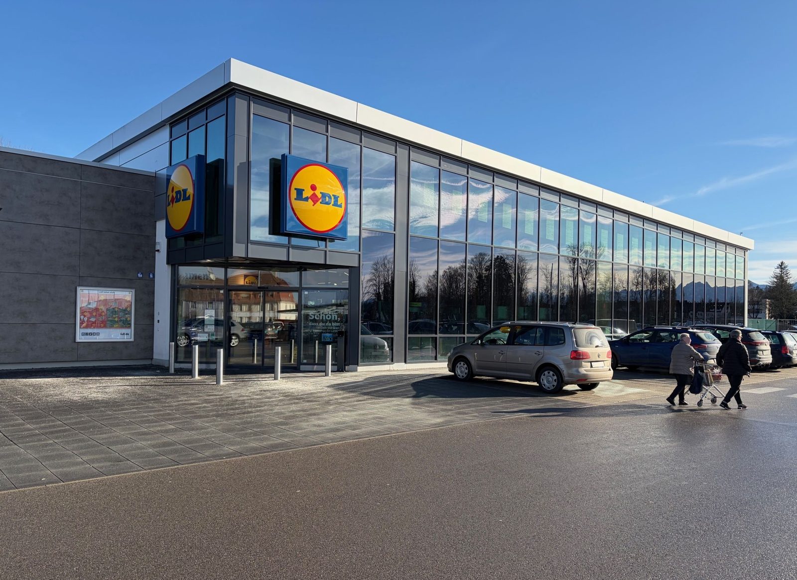 Außenansicht der neu errichteten Lidl-Filiale in Penzberg mit Glasfront und Eingangsbereich.